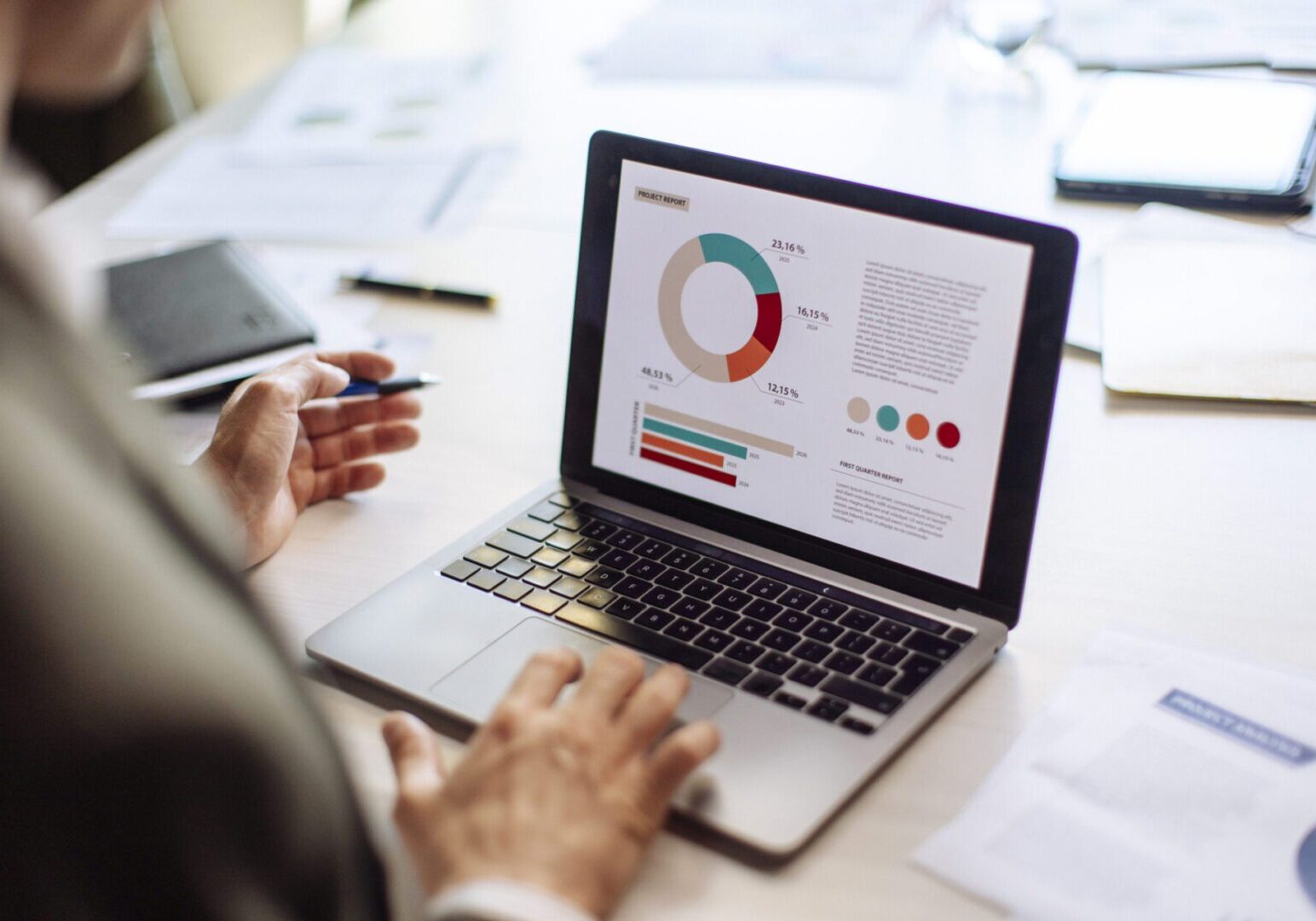 Person analyzing charts on a laptop screen.